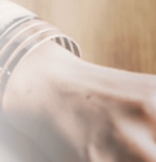 En handled med flera armband i en suddig, ljus miljö.