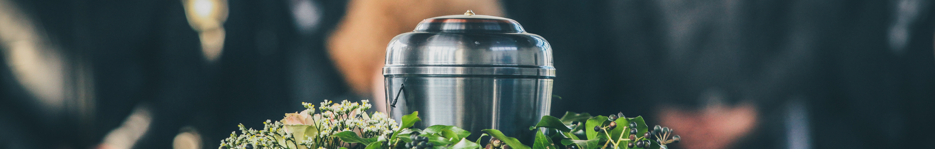 En stor metallgryta omgiven av gröna blad och mörka bär.