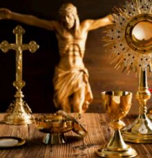 Ett altare med religiösa föremål som ett krucifix, kalkar och en monstrans i guld.