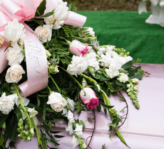 En kista med en bukett av vita och rosa blommor.
